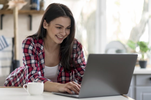 Mujer con computadora que ilustra cuánto tiempo antes debo reservar un hotel para obtener el mejor precio